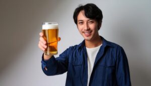 グレー背景でビールを差し出す人
