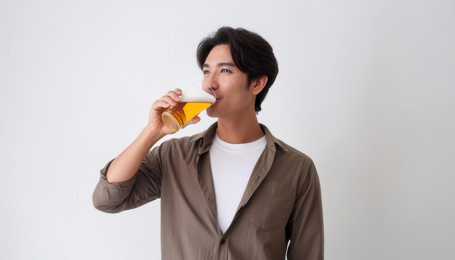 白背景でビールを飲む若い男性