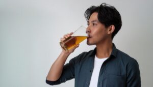 白背景でビールを飲むリラックスした若い男性