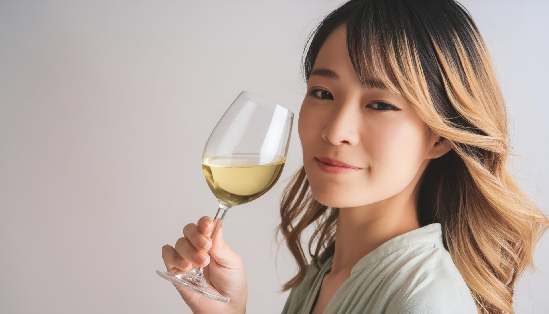 白背景で白ワインを見つめる人