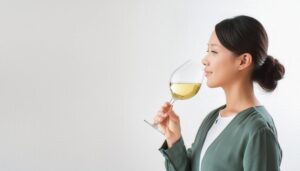 白背景で白ワインの香りを楽しむ人