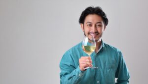 白背景で白ワインを手にする人