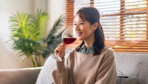 室内で赤ワインを楽しむ若い女性