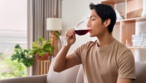 ソファで赤ワインを飲む人物