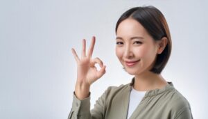 ショートヘアの人物がOKサインをする様子