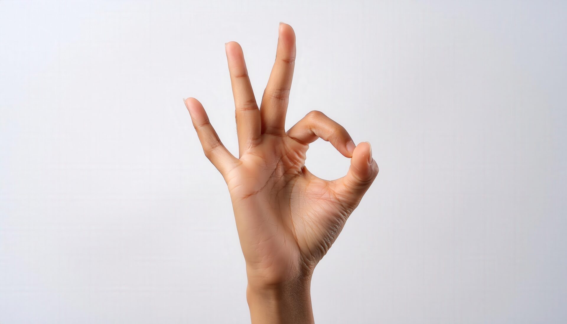 異なる肌色の手でOKサインをするクローズアップ