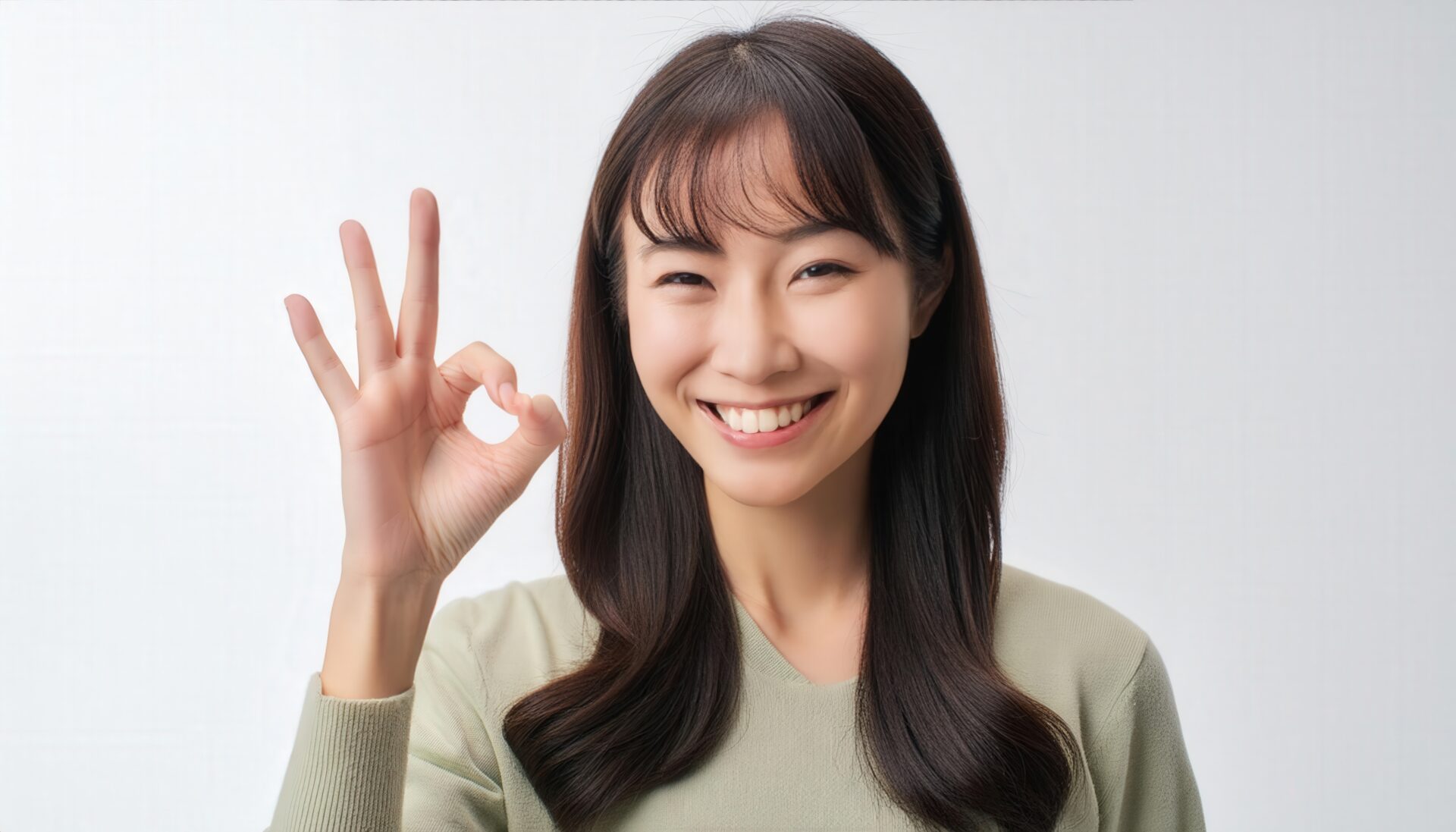 白背景でOKサインをするカジュアルな人物