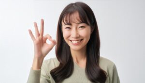 白背景でOKサインをするカジュアルな人物