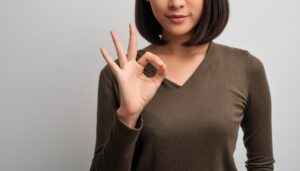 シンプル背景でOKサインをする人物（上半身）
