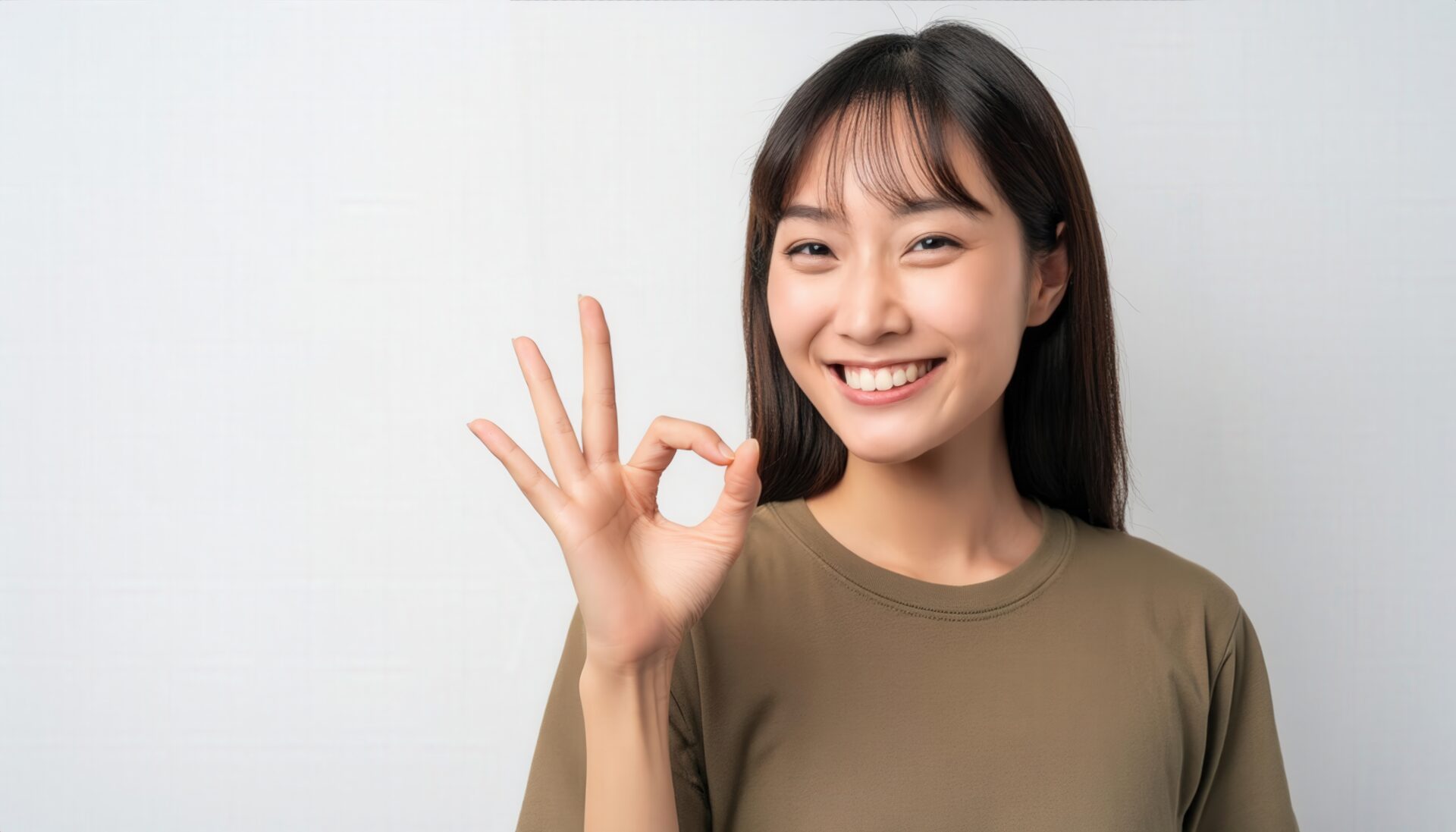 白背景でOKサインをする人物（ロングヘア）