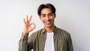 白背景でOKサインをする若い人物（カジュアル）