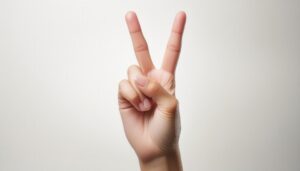 白背景でピースサインをする手