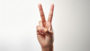 白背景でピースサインをする手