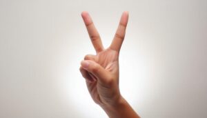 白背景でピースサインをする手