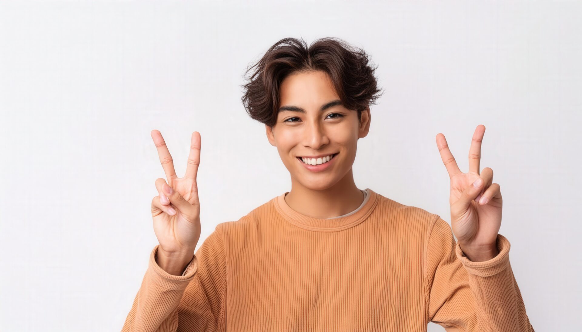 白背景で両手ピースサインをする若い男性