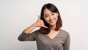 白背景で電話ジェスチャーをする人