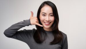 白背景で電話ジェスチャーをする人（別カット）