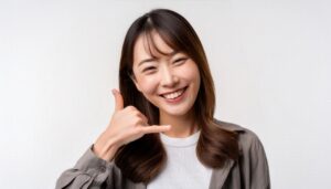 白背景で電話ジェスチャーをする人（前髪あり）