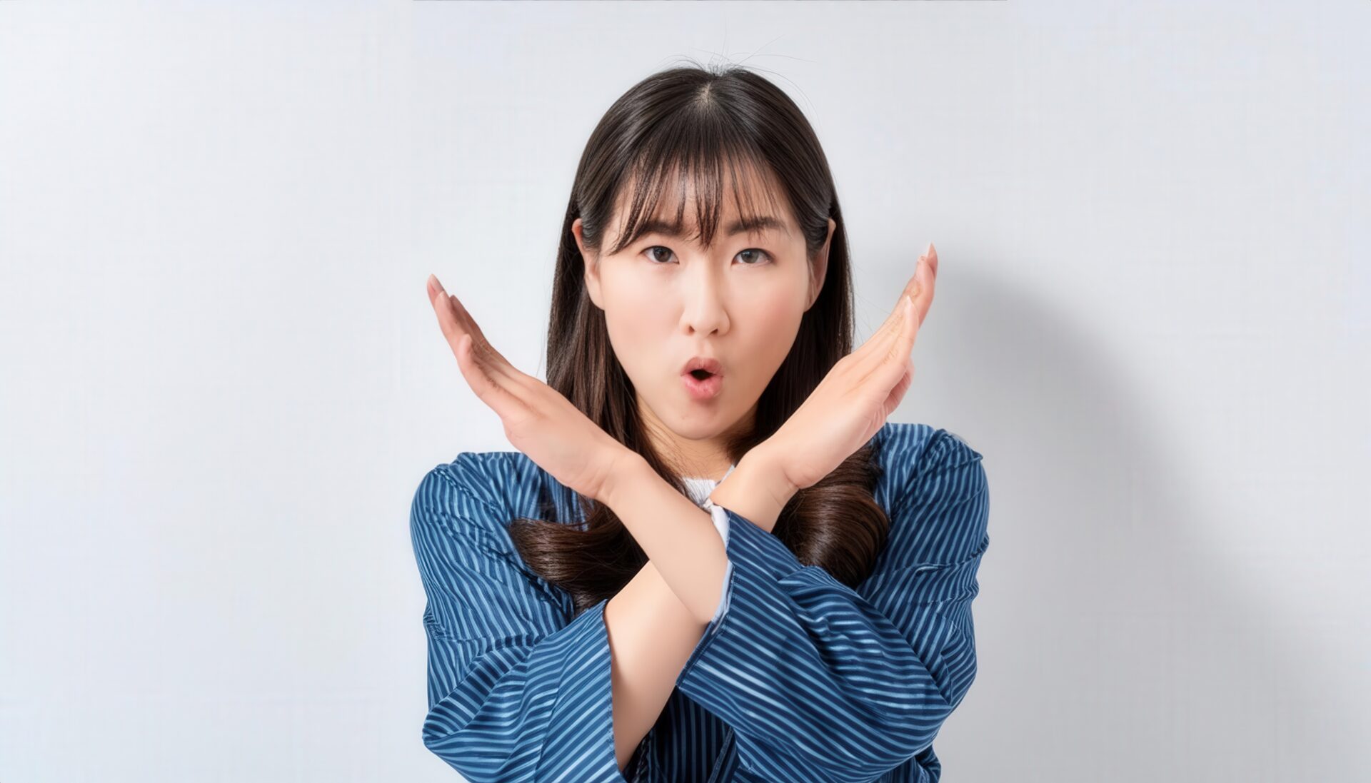 白背景で腕を交差させてバツ印を作る人