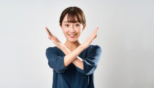 白背景でクロスサインを出す人