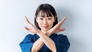 白背景で腕をクロスしてNGサインを示す女性