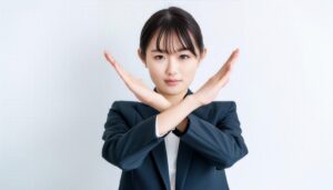 白背景でバツ印を示すビジネススタイルの女性