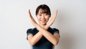 白背景で腕をクロスしてNGサインを示すスポーツウェアの人