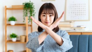 室内でストライプの服を着て腕をクロスしてNGサインを示す人