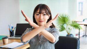 オフィスでギンガムチェックの服を着て腕をクロスしてNGサインを示す人