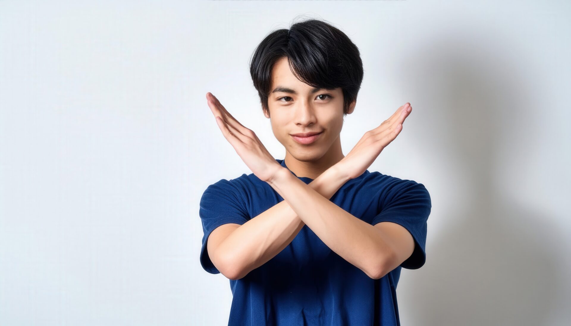 白背景でネイビーのTシャツを着て腕をクロスしてNGサインを示す人