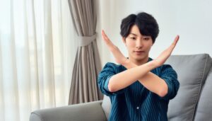 カーテンの前で腕をクロスしている若い人