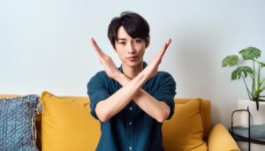 黄色いソファの前で腕をクロスしている若い人