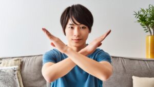 室内で腕をクロスしている若い人