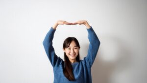 青いセーターで頭上に円を作っている若い人