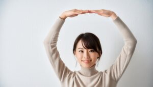ベージュのセーターで頭上に円を作っている若い人