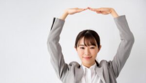 薄いグレーのスーツで頭上に円を作っている若い人