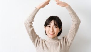 ベージュのセーターで頭上に円を作っている若い人
