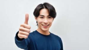 白背景で青いトップスの若者がサムズアップ