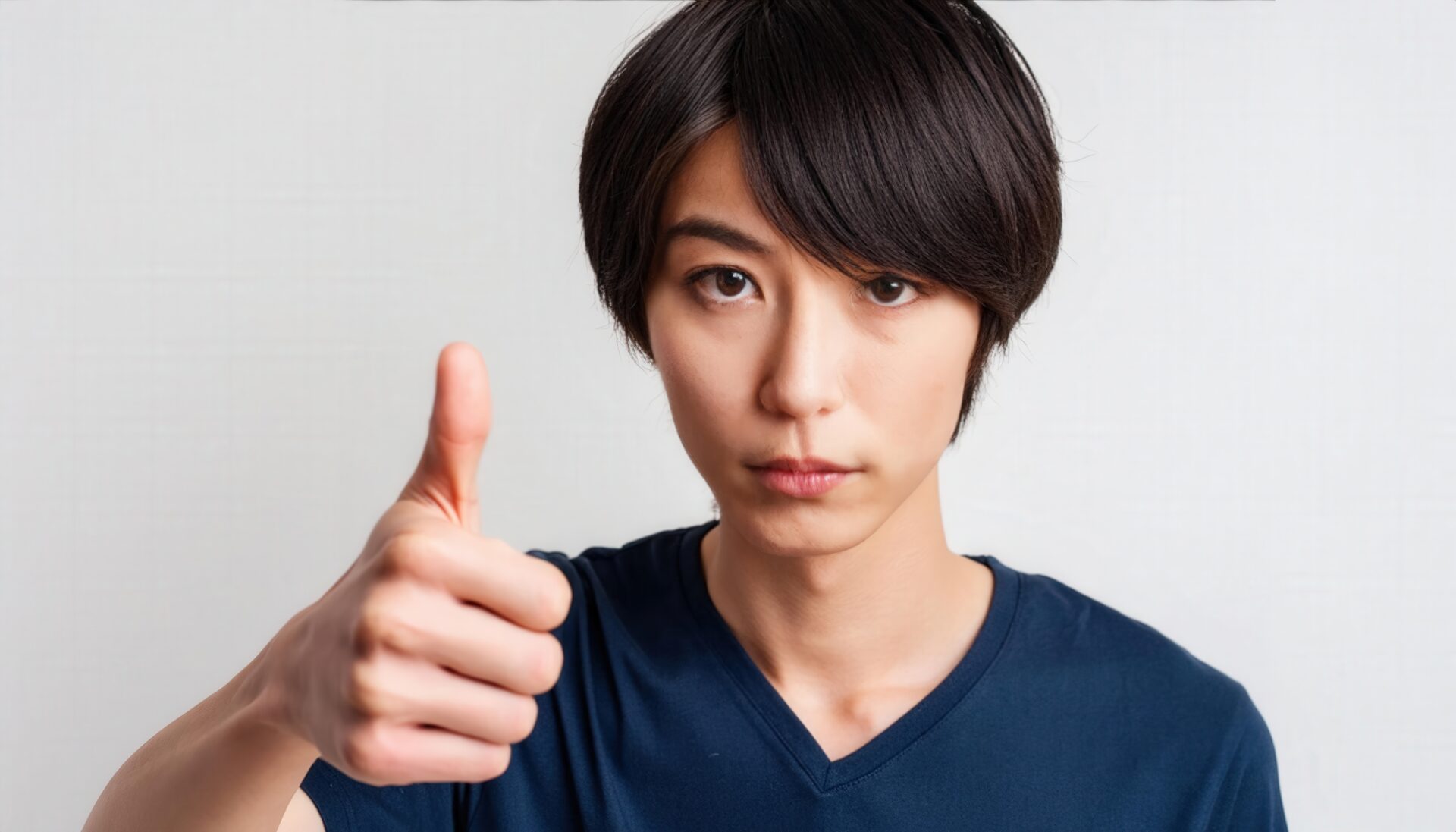 白背景でサムズアップをする若者