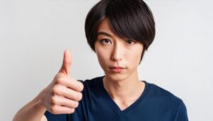 白背景でサムズアップをする若者