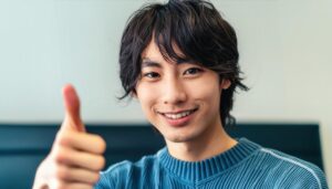 リビングでサムズアップをする人物