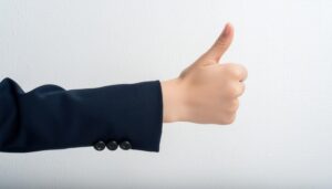 白背景でスーツの袖から親指を立てる手(2)