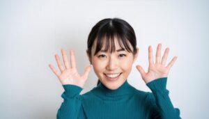 白背景で両手を広げるブルーのトップスを着た若い女性