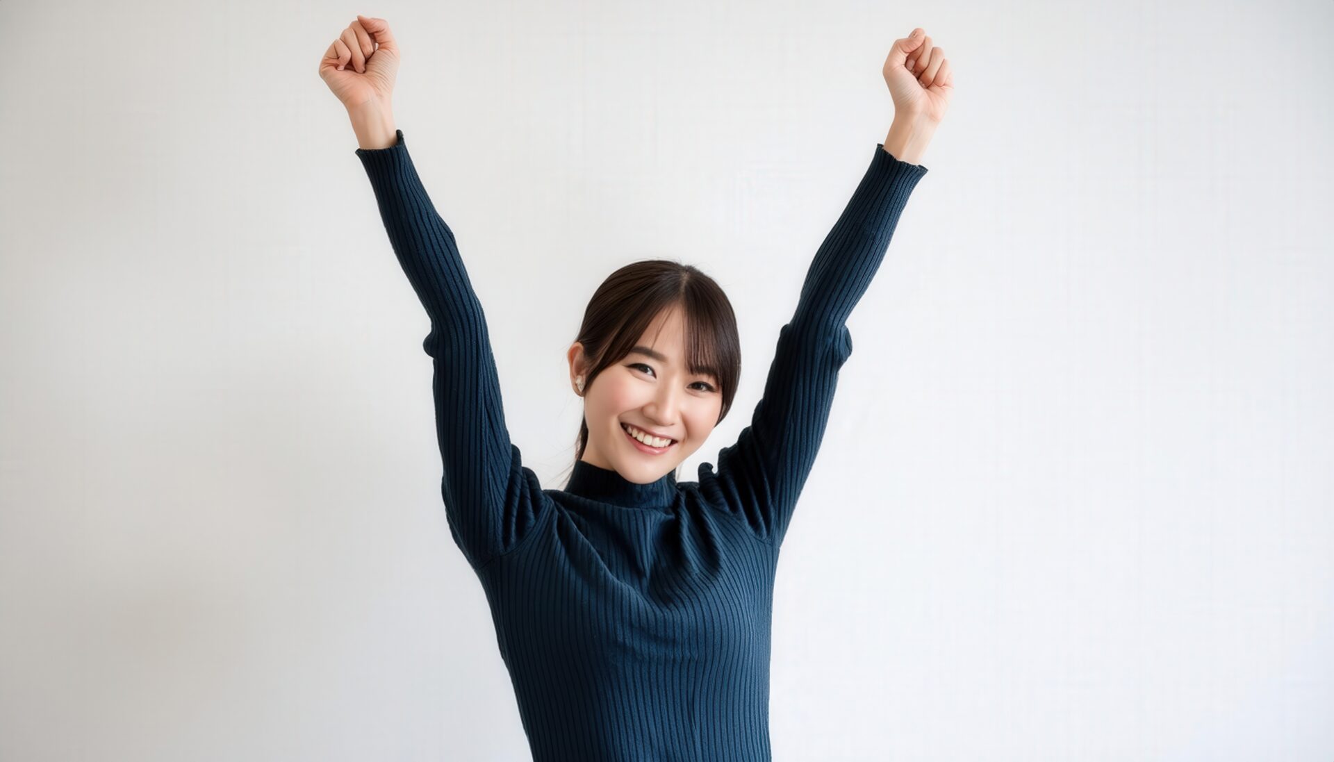 白背景で腕を上げる笑顔の若い女性