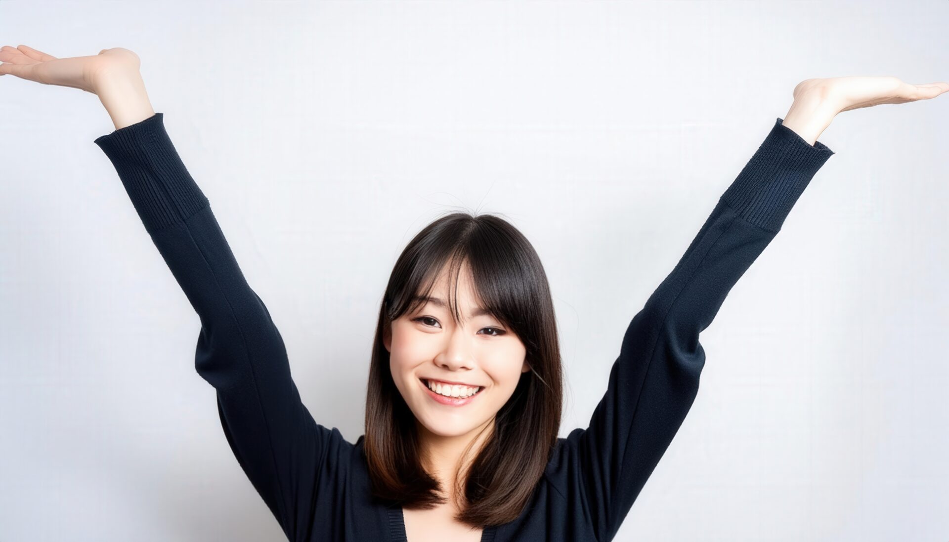 白背景で腕を上げて微笑む若い女性