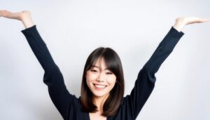 白背景で腕を上げて微笑む若い女性