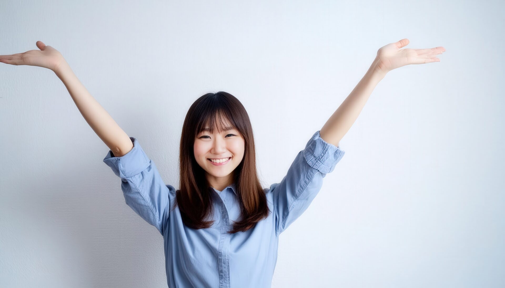 白背景で両腕を広げる笑顔の若い女性（シャツスタイル）
