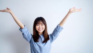 白背景で両腕を広げる笑顔の若い女性（シャツスタイル）