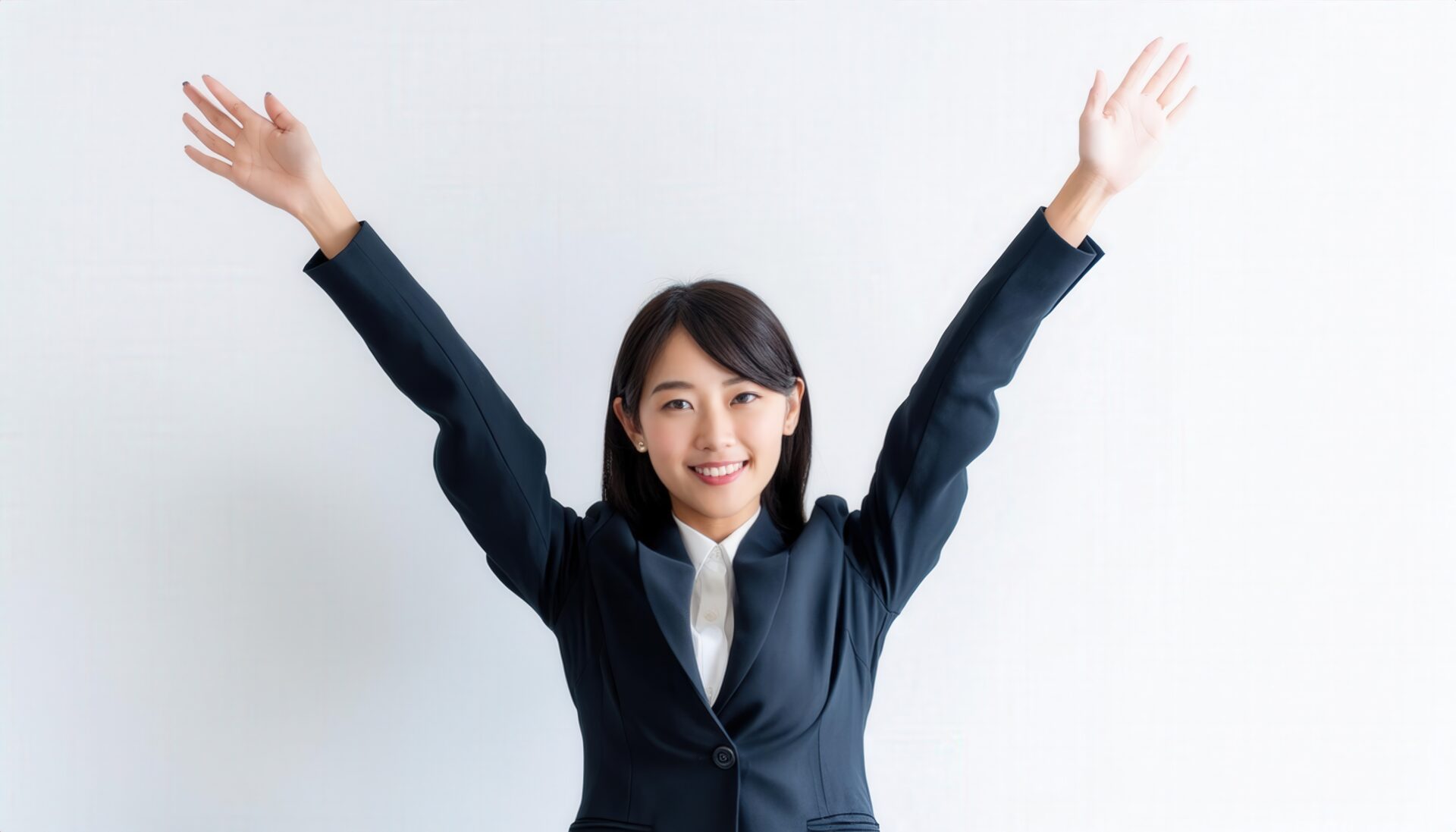 白背景で両腕を上げる笑顔の若い女性（ショートヘア）