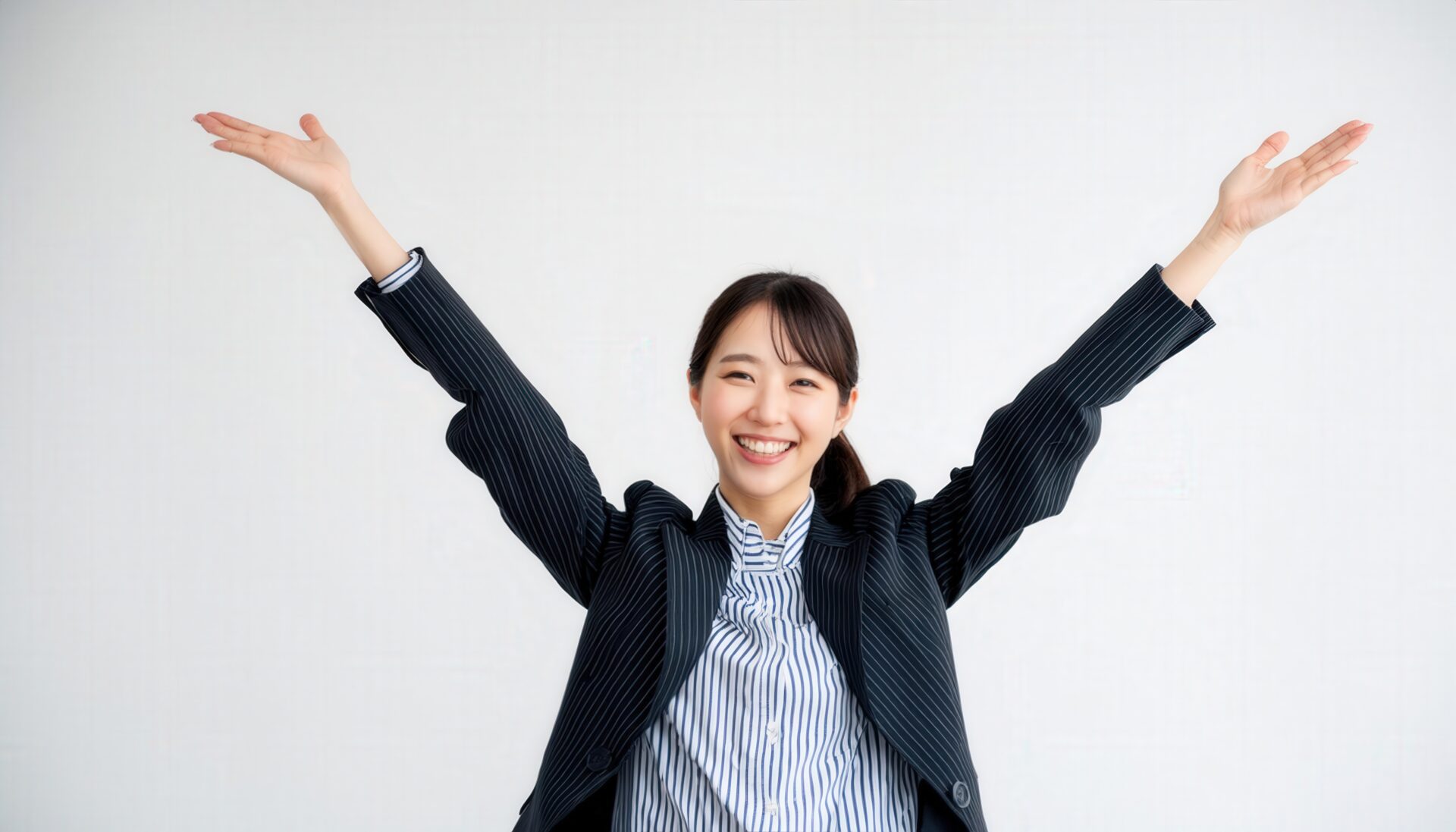 白背景でバンザイする笑顔の若い女性（ポニーテール）